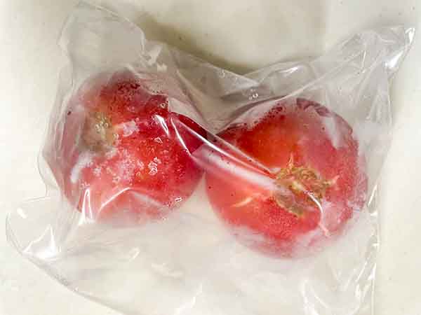 トマトを丸ごと冷凍（ヘタを取って保存袋に入れる）